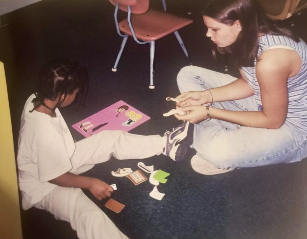 Priscalla Anne Edwrads sits on the floor, helping a child with a project at the Lee County Learning Center