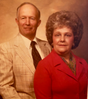 A.L. and Atha Setzer pictured seated in front of a photographer's backdrop.