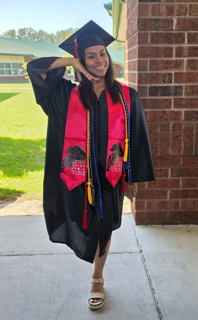 A young woman posing while preparing for her graduation